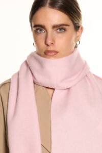 A professional styling shot of an oversized cashmere stole worn as a wrap, perfect for international festival travel.