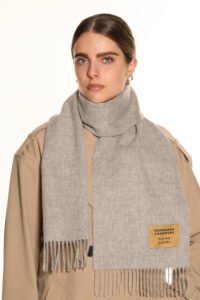 A stylised artistic arrangement of red and gold thistles surrounding a Thomson Red cashmere scarf.