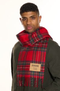 A model styled in a charcoal and red cashmere scarf, representing the brand's global appeal.